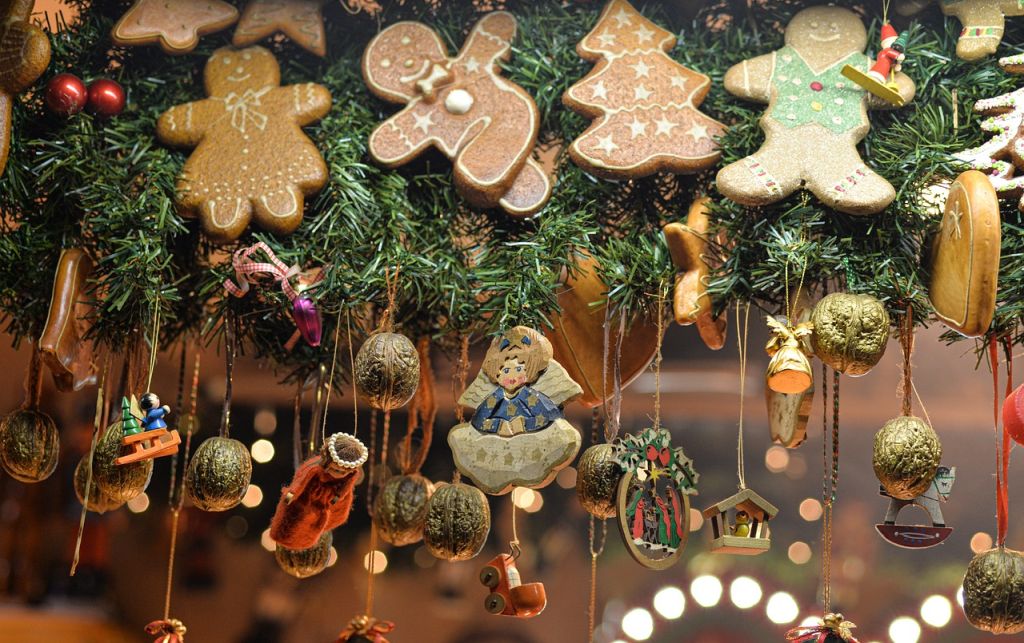 Blick auf einen Stand mit bunter weihnachtlicher Hängedekoration an grünen Tannenzweigen.       